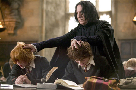 Snape from Harry Potter pushing down Harry and Ron's heads while they are studying their books in class.