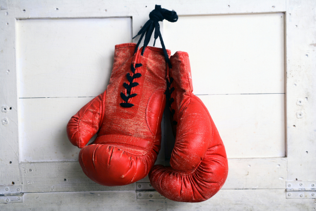 Red vintage boxing gloves hanging up on the wall.