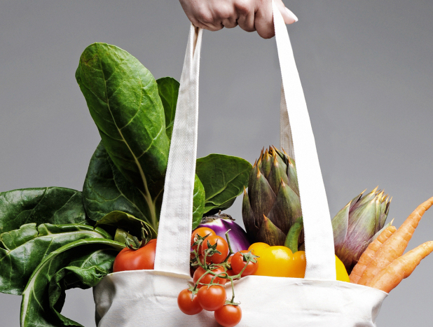 White tote bag filled with fresh produce and groceries