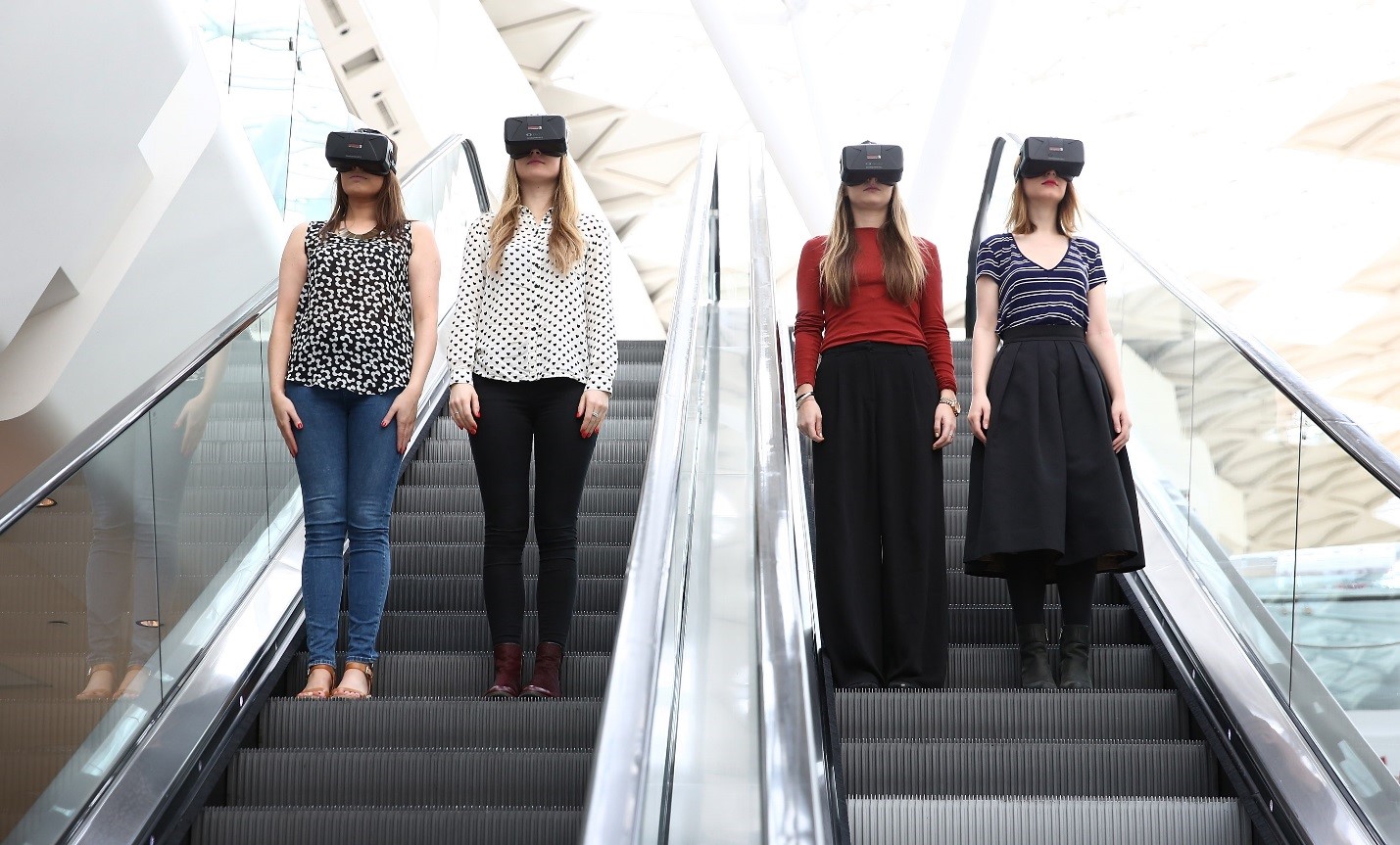 Girls standing on escalators wearing virtual reality headsets – virtual reality shopping – ecommerce trends for online businesses 