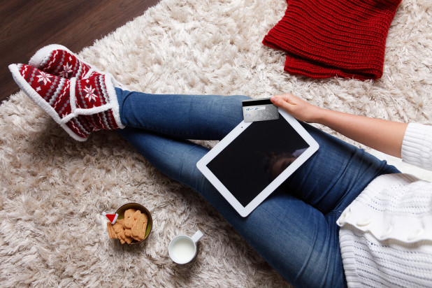 Girl sitting on floor with Christmas cookies and shopping online on tablet – Popular Black Friday and Cyber Monday Products Sold by Online Businesses