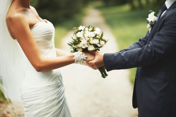 Photo of bride and groom holding hands
